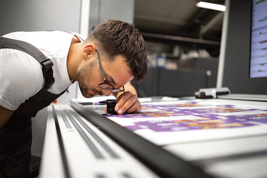ZippityPrint technician inspecting color consistency for G7 Master Targeted standards